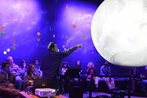 Speaker presenting to audience inside Planetarium