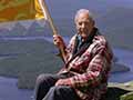 Man on cliff waving flag