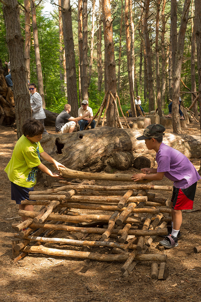 kids build a stick fort in the Pines Play area