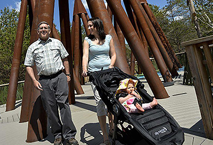 Man and woman walking with a baby in a stroller