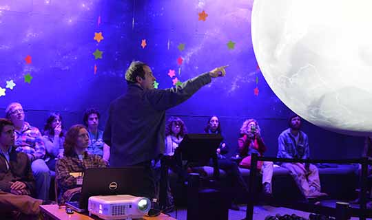 Speaker presenting to audience inside Planetarium