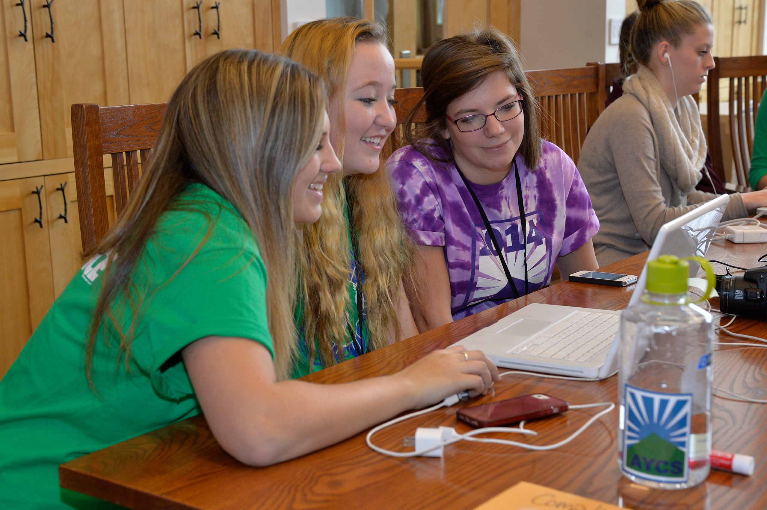 Three Youth Climate Summit Attendees observing laptop together