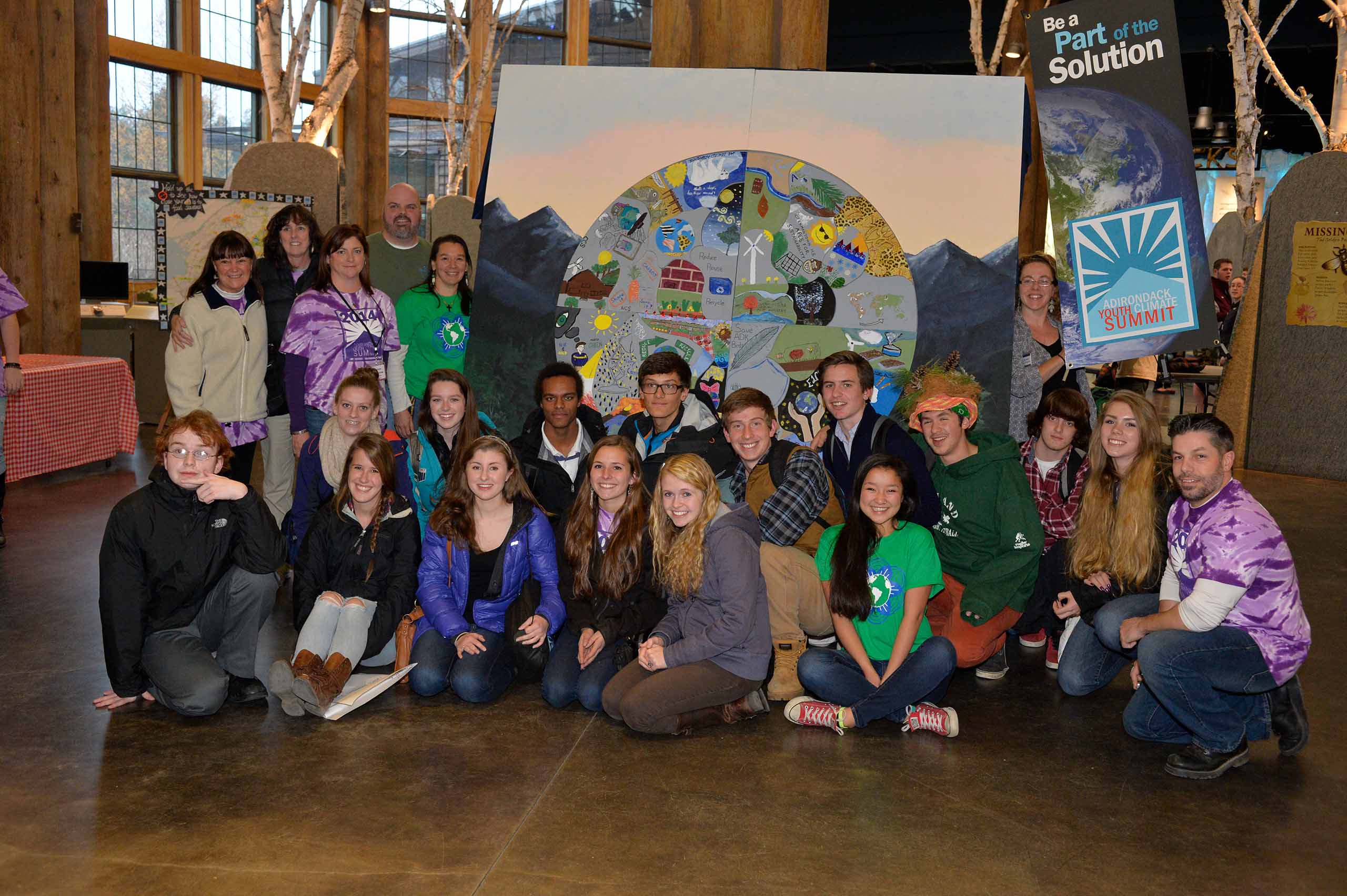Youth Climate Summit attendees posing in front of climate themed artowrk