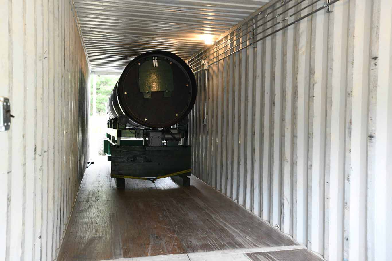 Composter being loaded into container