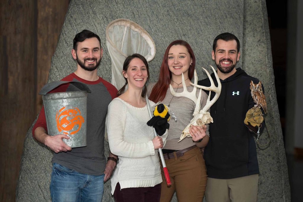 Group of intern fellows posing with various Wild Center items
