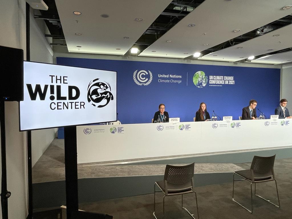 Wild Center logo on screen as delegation gives press conference