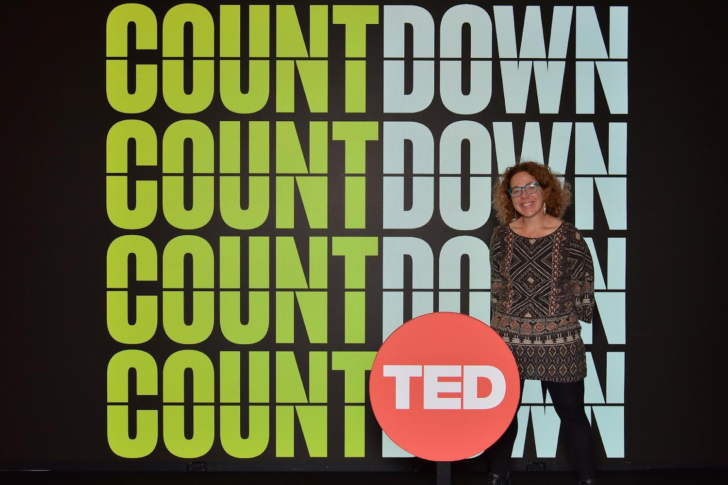 Jen posing in front of TED signage