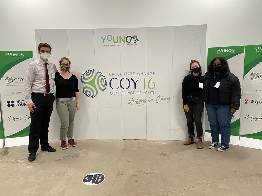 Group photo in front of Conference of Youth signage